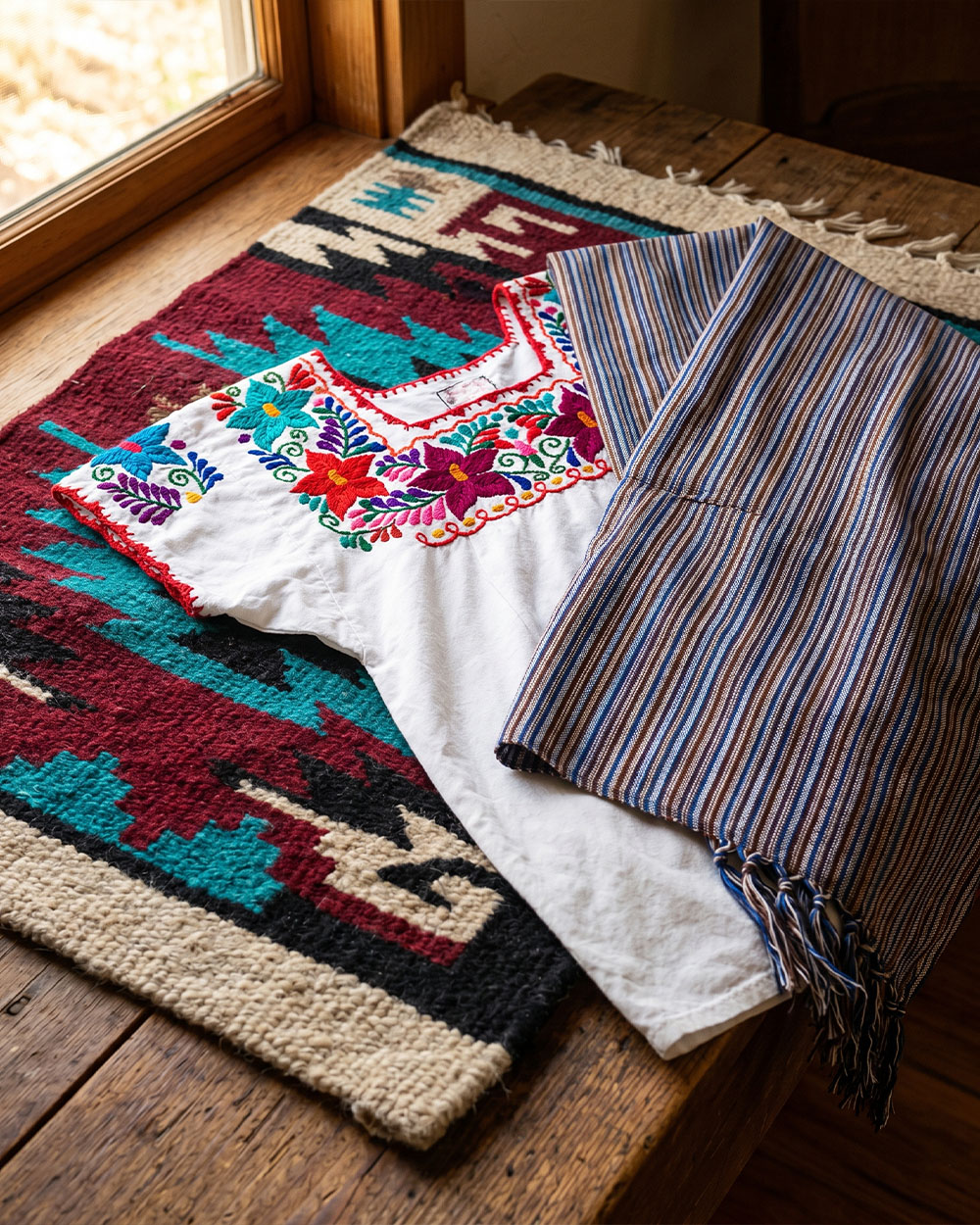 Handwoven Mexican textiles including wool rugs, huipiles, and rebozo shawls